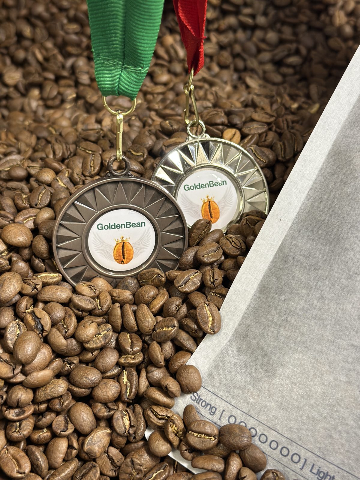 Golden Bean 2026 silver and bronze medals on fresh roasted coffee beans